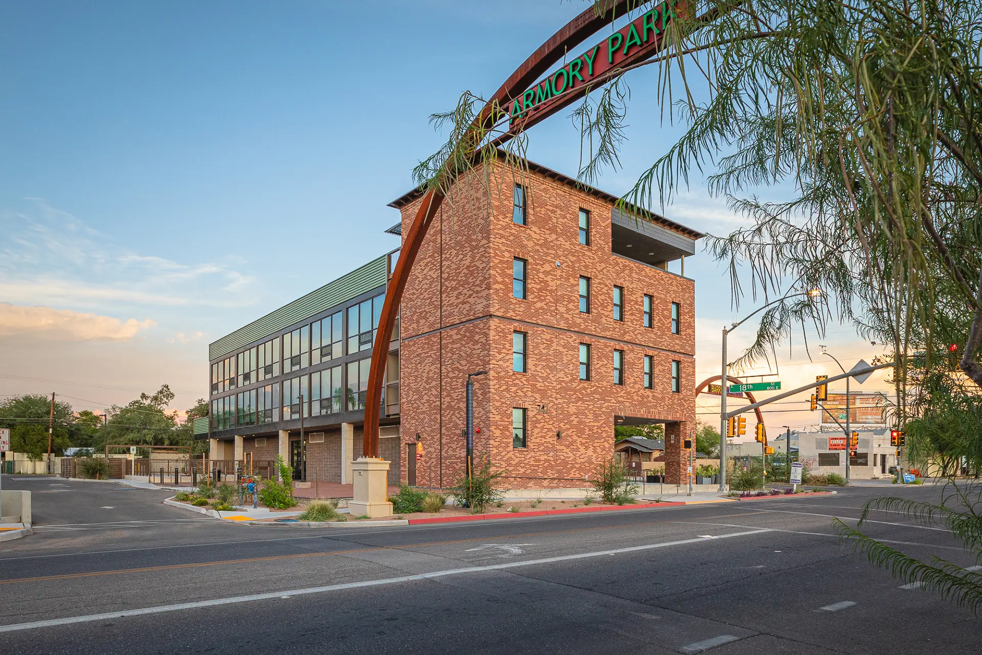 Commercial Real Estate and Property Management of a modern building with an arched sign over it displaying the name Armory Park adjacent to an interscetion on 18th in downtown Tucson.